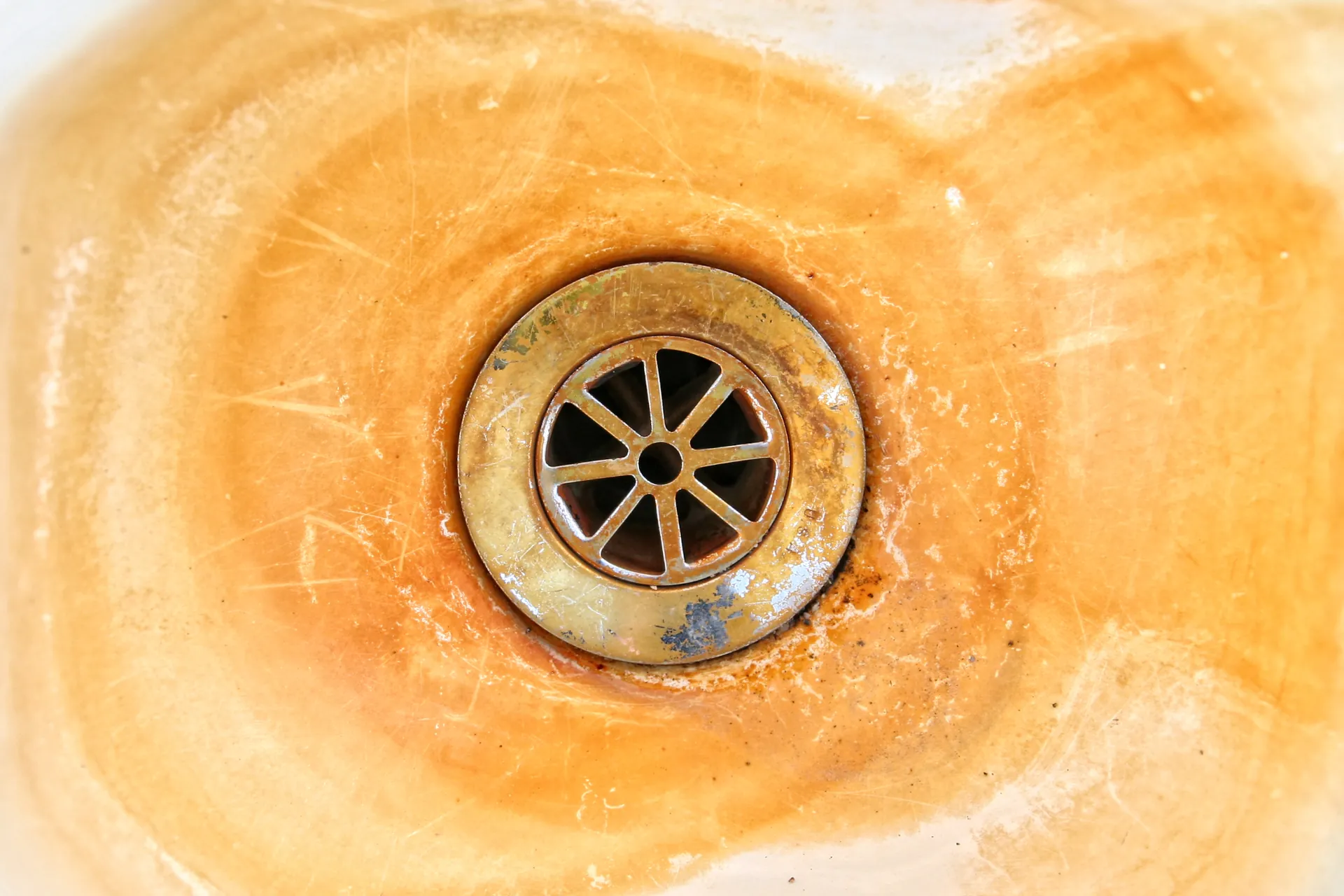 Rust-stained drain with brown residue